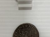 a close up of a coin on a white surface with a price tag