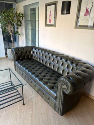 a black leather couch and a glass table in a living room