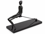 La statue d'un homme est posée sur un socle noir.