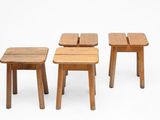 three small wooden stools sitting next to each other on a white surface