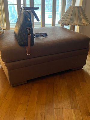 a louis vuitton bag sitting on top of a foot rest