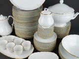 a lot of white and gold dishes and cups