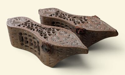 deux sabots en bois posés sur une surface blanche