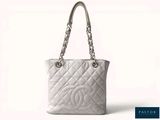 un sac Chanel blanc muni d'une poignée en chaîne argentée