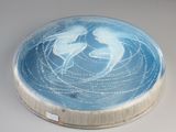 une assiette bleue sur laquelle est représentée une image de deux personnes