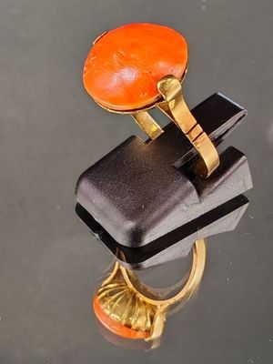 une bague en or surmontée d'une pierre orange