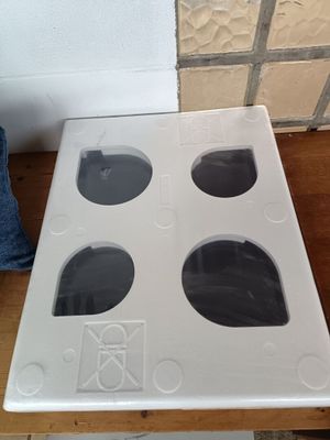 une cuisinière blanche à quatre feux posée sur une table
