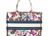 a white and blue floral bag with a striped handle