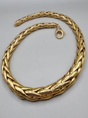 un collier plaqué or présentant un motif de tresse sur fond blanc