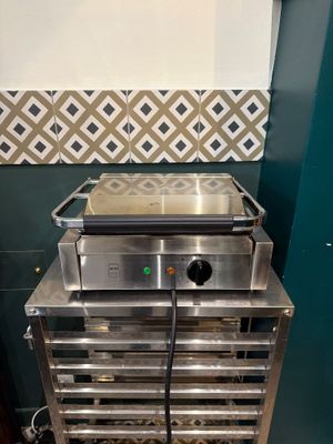un four argenté posé sur une grille métallique