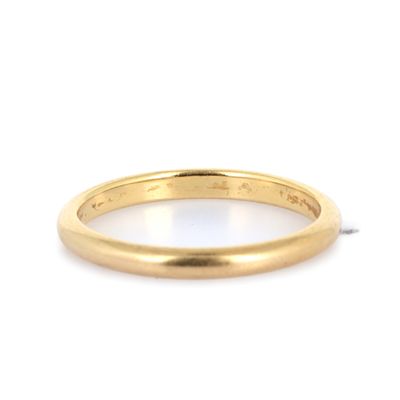 un gros plan d'une bague en or jaune sur fond blanc