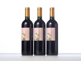 three bottles of wine are lined up on a table