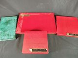 three red and green books sitting on top of a table