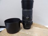 a camera lens sitting next to a cup on a wooden table