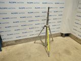 an image of a tripod stands in front of a wall with a sign on it