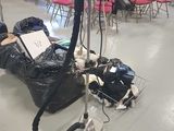 un sac poubelle posé par terre à côté d'un aspirateur