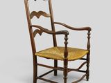 an old wooden chair with a yellow seat on a gray background