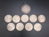 several silver coins sitting on top of a table next to a coin