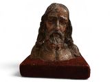 un vieux buste en bronze représentant un homme aux cheveux longs et à la barbe fournie
