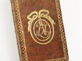 an old book with a gold - plated monogram on the cover