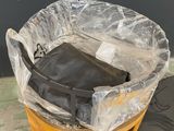 a black bag sitting in a plastic bag on top of a barrel