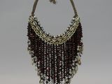 a necklace made of shells and beads on a stand
