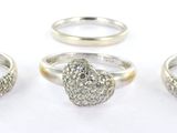 trois bagues en argent sur un fond blanc, avec un diamant au centre