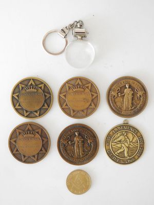 Plusieurs pièces de monnaie et un porte-clés sont posés sur une surface blanche