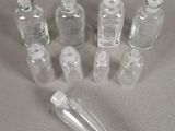 several empty glass bottles and a bottle opener on a white surface