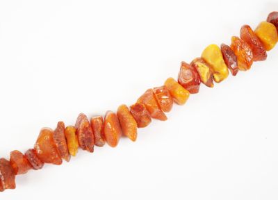 un gros plan sur un collier composé de perles orange et jaunes