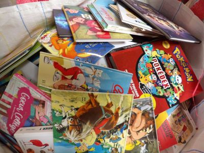 many children ' s books in a box on the floor