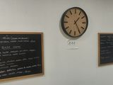 two clocks on the wall next to a blackboard