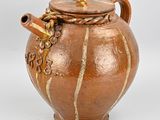 un vase marron muni d'une anse et d'un couvercle