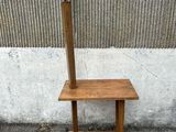une table en bois sur laquelle est posée une lampe, à côté d'un mur en béton