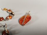 two pieces of jewelry sitting on a white surface