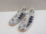 a pair of silver and blue sneakers on a white surface
