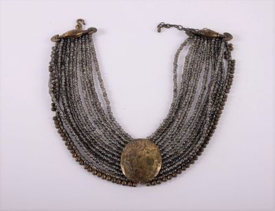 a close up of a necklace on a white surface