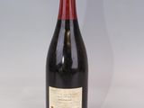 une vieille bouteille de vin posée sur une table blanche