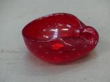 a red glass bowl that is sitting on a table