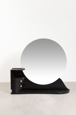 un miroir rond posé sur un socle en bois