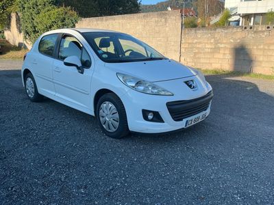 une voiture blanche garée sur un parking, près d'un mur de briques
