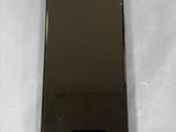a close up of a black cell phone on a white surface