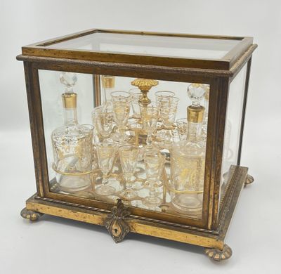 an antique brass and glass display case with a lot of glasses in it