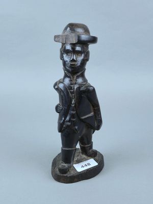 statue d'un homme coiffé d'un chapeau et tenant un pistolet