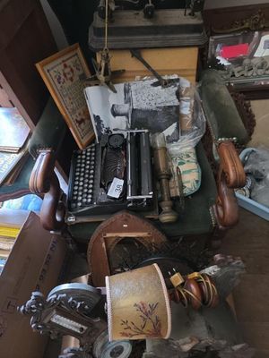 une pile de vieilles machines à écrire et d'autres objets posés sur une table