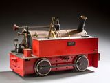 un petit train avec une locomotive rouge sur un fond blanc