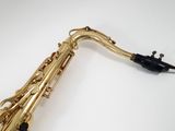 a close up of a saxophone on a white surface
