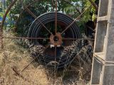 a large wheel sitting in the middle of a field