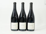 trois bouteilles de vin sont posées sur une surface blanche, sur fond blanc