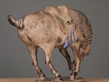 statue of a horse with a saddle on its back on a wooden table